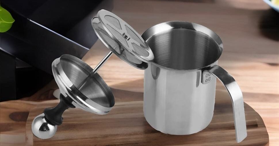 Making a creamy latte Using a handheld milk frother In kitchen
