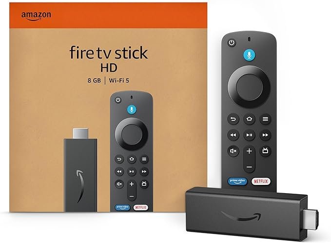 Amazon Fire TV Stick HD (2025) with Alexa voice remote, plugged into a smart TV showing live TV apps like YouTube, Prime Video, and Zee5 interface