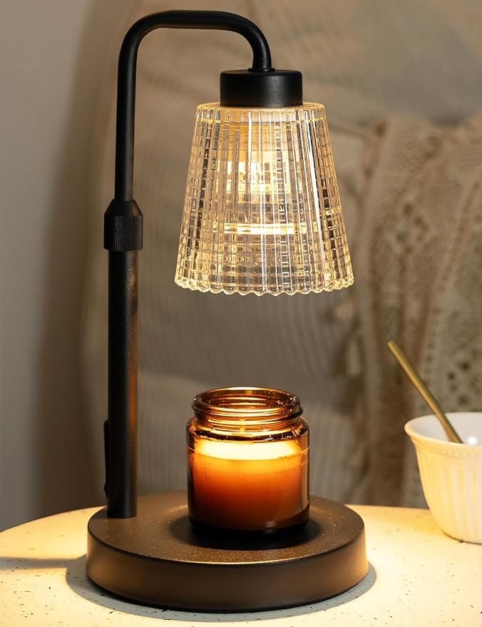 Elegant candle warmer lamp with dimmable bulb, gently melting a jar candle on a wooden nightstand in a cozy bedroom home décor.