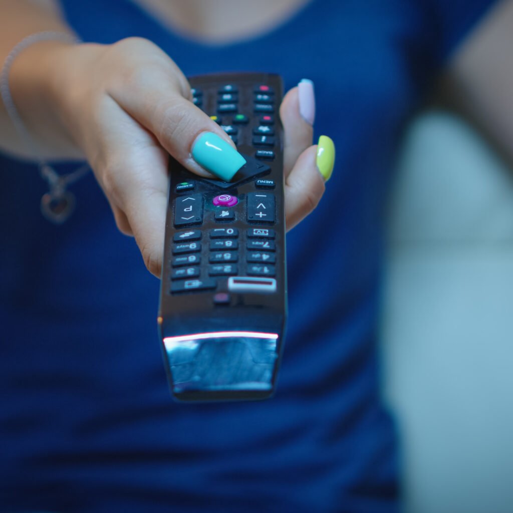 "Fire TV Stick placed next to a TV showing streaming apps like Netflix and Prime Video"