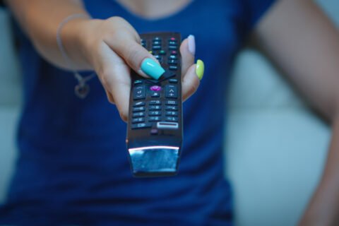 "Fire TV Stick placed next to a TV showing streaming apps like Netflix and Prime Video"