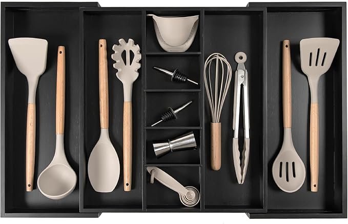 Adjustable kitchen organizer drawer made of bamboo, fully expanded with utensils neatly placed inside various compartments.